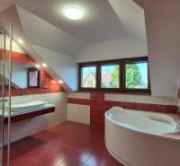 Fürdőszoba sarokkáddal és zuhanyzóval a családi házban.