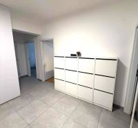 Tágas folyosó világos csempékkel és fehér komóddal egy 4 szobás lakásban.