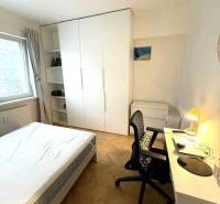 Hálószoba egy 4 szobás lakásban fehér bútorokkal és fa dekorációjú padlóval.