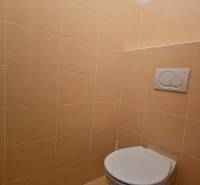 Bézs csempékkel ellátott mosdó üzlethelyiségben.