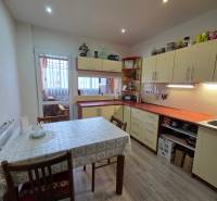 Konyha egy háromszobás lakásban fa dekor padlóval és étkezőasztallal.