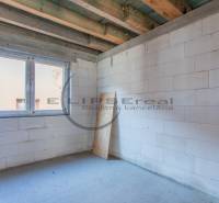 Fehér falakkal és nagy ablaknyílással rendelkező épület.