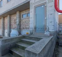 Egy épület Nagylévárdon befejezetlen homlokzattal és beton alapú lépcsőkkel.