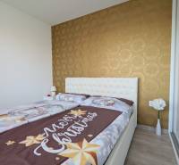 Hálószoba karácsonyi ágyneművel, tapétával és virágokkal egy háromszobás lakásban.