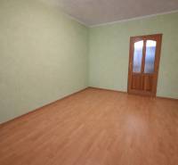 Üres szoba fa dekor padlóval és zöld falakkal egy kétszobás lakásban.