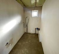 Üres szoba ablakkal egy családi házban, látható szerelvények és előkészítés a berendezéshez.