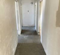 Egy családi ház folyosója befejezetlen mennyezettel és betonpadlóval.