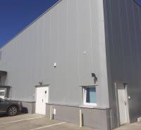 Raktárak és csarnokok a Pozsony-Ružinov Technikai utcában, parkoló autókkal a bejárat előtt.