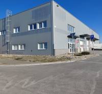 Raktárak és csarnokok a Pozsony-Ružinov Technikai utcában parkolóval és közlekedési táblákkal.