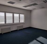 Raktárak és csarnokok belső tere kék szőnyeggel, nagy ablakokkal és fehér falakkal.