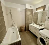 Fürdőszoba káddal, dupla mosdóval és mosógéppel egy háromszobás lakásban.