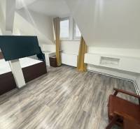 Szoba fa dekorációjú padlóval, modern televízióval és bútorokkal egy egyszobás lakásban.