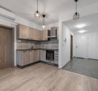 A kétszobás lakás konyhája fa dekor padlóval és beépített világítással.