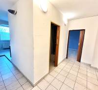 Folyosó egy 3 szobás lakásban járólappal, nyitott ajtók, átjáró a helyiségbe.