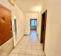 Folyosó egy 3 szobás lakásban csempével és bejárati ajtóval.