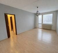 Szoba fa dekorációs padlóval és csillárral egy háromszobás lakásban.