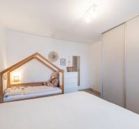 Gyerekszoba egy kétszobás lakásban, gyerekággyal és szekrénnyel.