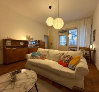 Nappali egy kétszobás lakásban, fa dekorációjú padlóval és kényelmes kanapéval.