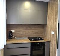 Konyha egy 3 szobás lakásban modern készülékekkel és fa hatású padlóval.