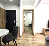 3 szobás lakás belső tere fa dekoros padlóval és stílusos asztallal.