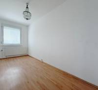 Egy négy szobás lakás szobája csillárral és fa dekorációjú padlóval.