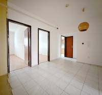 Egy 4 szobás lakás belső tere fehér falakkal, csempével és fa dekorációjú padlóval.