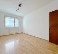 Üres szoba egy négy szobás lakásban, fa dekor padlóval és nagy ablakkal.