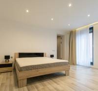 Hálószoba egy kétszobás lakásban ággyal, éjjeliszekrénnyel és fa dekorációjú padlóval.