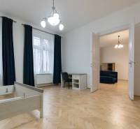 3 szobás lakás belső tere fa dekorációjú padlóval, bútorokkal és csillárral.