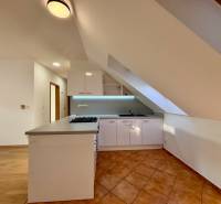 Konyha egy kétszobás lakásban konyhabútorral és kerámia padlóval.