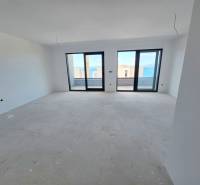 Nyaraló apartman belső tere nagy ablakokkal, kilátással a tengerre.