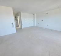 Nyaraló apartman tiszta fehér falakkal és tágas, fa dekorációjú padlóval.