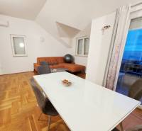 Étkező és nappali egy üdülő apartmanban fa dekorációjú padlóval.