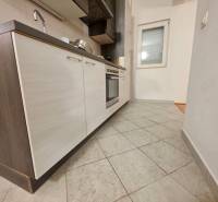 Konyha egy nyaraló apartmanban csempével és modern konyhabútorral, sötét szekrényekkel.