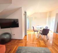 Egy nyaraló apartman belső tere fa dekor padlóval és étkezőasztallal.