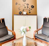 Két szék egy kétszobás lakásban virágdíszítéssel és fa dekorációjú padlóval.