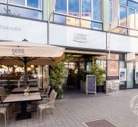 A pozsonyi Yeme külseje a Medena utcában, kültéri ülőhelyekkel és a Slovenská sporiteľňa bankautomatájával.