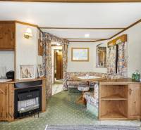 Egy kunyhó belseje vintage bútorokkal és szőnyeggel, természetes fénnyel megvilágítva.