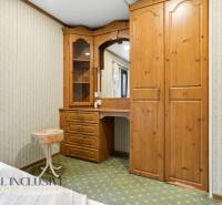 Fa bútor tükörrel és mintás tapétával a kunyhó belsejében.