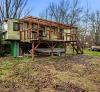 Ház Gabčíkovo-ban terasszal és lépcsőkkel, hajó a tető alatt, őszi táj.