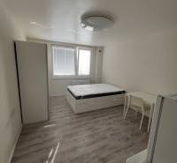 Garzonlakás ággyal, szekrénnyel, asztallal és fa dekorációjú padlóval.