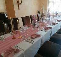 Stílusos belső tér vendégek számára asztallal a szállodákban és panziókban, gyertyákkal és virágokkal díszítve.