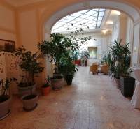 Folyosó szállodák és panziók virágokkal és ülőhelyekkel, dekoratív padlóval.