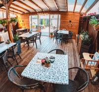 A fapadlós dekorációval rendelkező szállodákban és panziókban asztalok, székek és virágok találhatók.