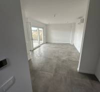 Nappali egy háromszobás lakásban terasszal és szürke csempével.