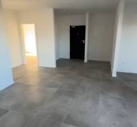 3 szobás lakás belső tere nagy csempékkel és fehér falakkal.