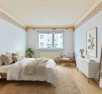 Hálószoba ággyal, szőnyeggel, székkel, dekorációkkal, fa dekorú padlóval.