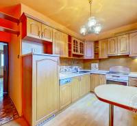 Konyha egy 3 szobás lakásban beépített készülékekkel és fa hatású padlóval.