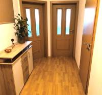 Előszoba egy kétszobás lakásban fa dekorációjú padlóval és fa bútorokkal.