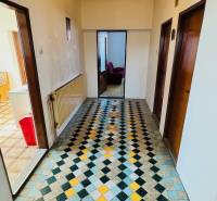 Egy családi ház folyosója színes csempével, faajtókkal és radiátorral.